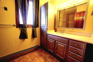 安克雷奇Quiet And Comfortable Deluxe的一间带水槽和镜子的浴室以及窗户。