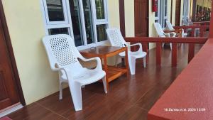 高兰Sleep In Lanta Resort的门廊上的一排白色椅子和一张桌子