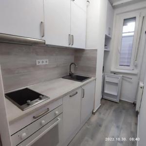 沙托劳尔尧乌伊海伊LBB apartman的厨房配有白色橱柜、水槽和窗户。