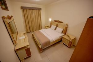 阿吉曼AL MARJAN FURNISHED APARTMENTS的酒店客房,配有床和镜子