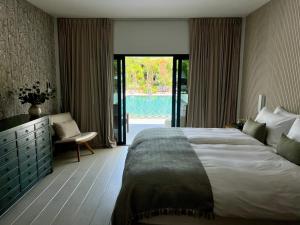 苏梅岛Moorea Boutique Resort Samui的一间卧室设有一张大床和一个滑动玻璃门