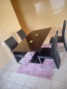 Ghana TownCostal Road hideout!的一张桌子、两把椅子和一台笔记本电脑