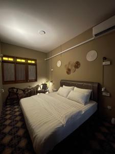马六甲The Grand Bali Hotel的卧室配有一张带白色床单和枕头的大床。