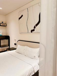 绥和市Apec Mandala HaDoFinn的卧室配有白色的床和电视