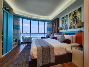 马累The Hive Beach的一间卧室设有一张大床和大窗户