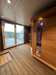 卑尔根Villa Arboretet - Seaside villa with private pool & infrared sauna in the heart of Arboretet, Bergen的客房设有带大窗户的木制甲板。