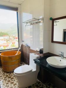 萨帕Sapa indigo inn的带浴缸、卫生间和盥洗盆的浴室