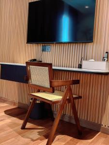 乔治市The Palm Suite@Chusan的一张桌子上的木椅,配有电视