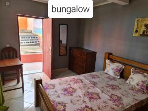AntsakomboenaVILLA FPC的一间卧室配有一张床、一个梳妆台和一扇窗户。