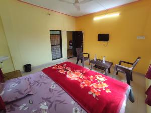戴维格Shri Krupa Homestay的卧室配有一张床和一张桌子及椅子