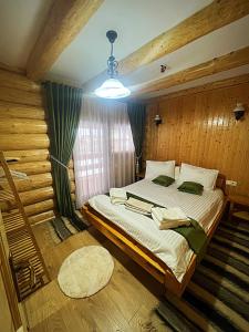 LeordinaPensiunea Casa Cătanelor的一间带一张大床的卧室,位于带木墙的房间