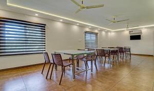科钦Treebo Trend Golden Terminal Kochi Airport的用餐室设有桌椅和窗户。