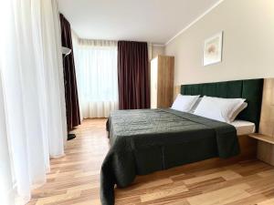 圣弗拉斯西内瓦太阳海岸公寓式酒店的一间卧室配有一张带绿色床头板的床