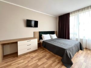 圣弗拉斯西内瓦太阳海岸公寓式酒店的一间卧室配有一张床和一张书桌及电视