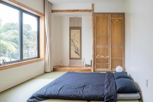 顺化Hajime Homestay Hue的一间卧室设有一张床和一个大窗户