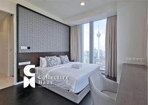 吉隆坡Tropicana Residences Kuala Lumpur by Collective Haus的卧室配有床、椅子和窗户。