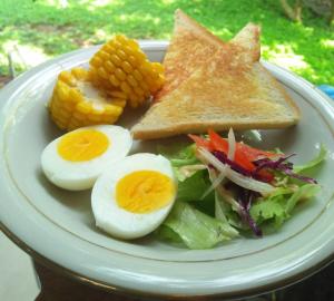 玛琅Condro Wulan Hostel的鸡蛋,沙拉和玉米等食物