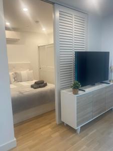 直布罗陀CP Top floor luxury studio with spa and pool的一间卧室配有大屏幕平面电视和一张床