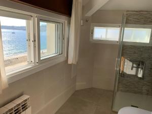 坎加斯德穆拉索普拉亚酒店的带淋浴的浴室和窗户。