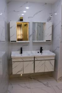 安曼Amman Trail Hostel的白色的浴室设有两个盥洗盆和镜子