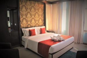 kolkataGEETANJALI REGENCY的一间卧室,配有一张带鲜花的床