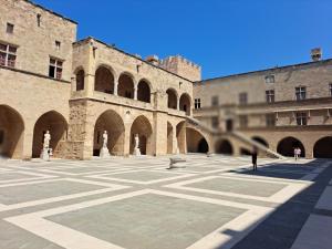 罗德镇The Retreat in the heart of Old Town Rhodes的大型庭院,设有拱门建筑