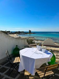 圣伊西多罗Villa GAUDÌ的一张带椅子的白色桌子,享有海滩美景