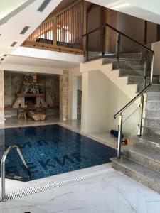 AndrijevicaVila Djekic的一座带楼梯的房屋内的游泳池