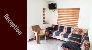 蒂鲁帕蒂SRI HARI KIRAN GRAND TIRUPATI. Alipiri Road的客厅配有沙发和椅子