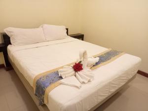 春蓬ไลอ้อน โฮเทล的一张白色的床,上面有花