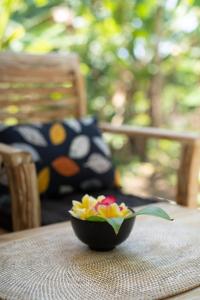 甘地达萨Jepun Didulu Cottages的坐在桌子上的一碗鲜花