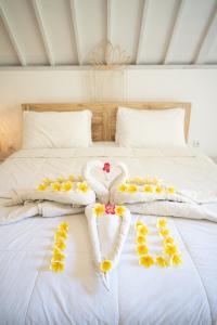 甘地达萨Jepun Didulu Cottages的一张带毛巾和鲜花的白色床