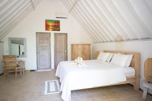 甘地达萨Jepun Didulu Cottages的卧室配有白色的床和娃娃