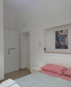 圣维托诺曼Suite Europa的白色卧室配有一张床,墙上挂着一幅画