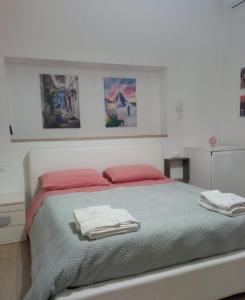 圣维托诺曼Suite Europa的一间卧室配有一张床,上面有两条毛巾