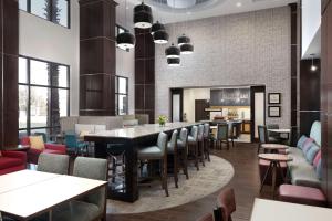 埃尔帕索帕索机场汉普顿套房酒店 的餐厅设有酒吧,配有桌椅
