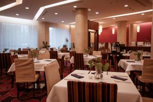 布拉迪斯拉发希尔顿逸林酒店布拉迪斯拉发的一间设有白色桌椅的用餐室