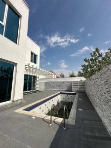 迪拜Centerpoint Duplex Villa的一座建筑,设有游泳池,毗邻砖墙