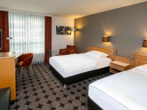 纽伦堡纽伦堡机场瑞享酒店的酒店客房配有两张床和一张书桌