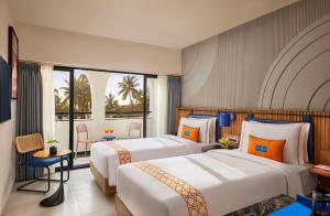 卡兰古特Ronil Goa - a JdV by Hyatt Hotel的酒店客房设有两张床和一个阳台。