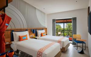 卡兰古特Ronil Goa - a JdV by Hyatt Hotel的酒店客房设有两张床和窗户。