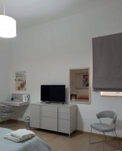 圣维托诺曼Suite Europa的客厅配有电视、书桌和椅子