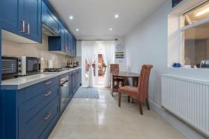 伦敦Stunning 3-Bed House的厨房配有蓝色橱柜和桌子