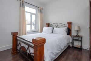 伦敦Stunning 3-Bed House的一间卧室配有一张带白色床单的床和一扇窗户。