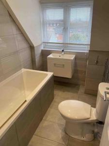 科巴姆Luxury Penthouse Appartment的浴室配有卫生间、浴缸和水槽。