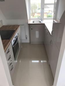 科巴姆Luxury Penthouse Appartment的白色的小厨房,配有水槽和窗户