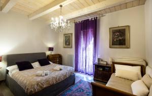 拉文纳Al Battistero Luxury Suite的一间卧室配有一张床和一个吊灯