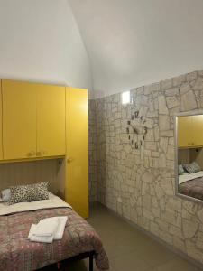 维耶斯泰Monolocale Elena的一间卧室设有石墙、一张床和镜子