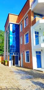 RubavuKivu Summer Hotel的一面设有蓝色门的砖砌建筑