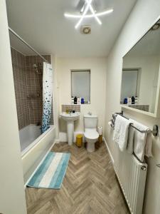 伍尔弗汉普顿Beautiful Home in Wolverhampton!的浴室配有盥洗盆、卫生间和浴缸。